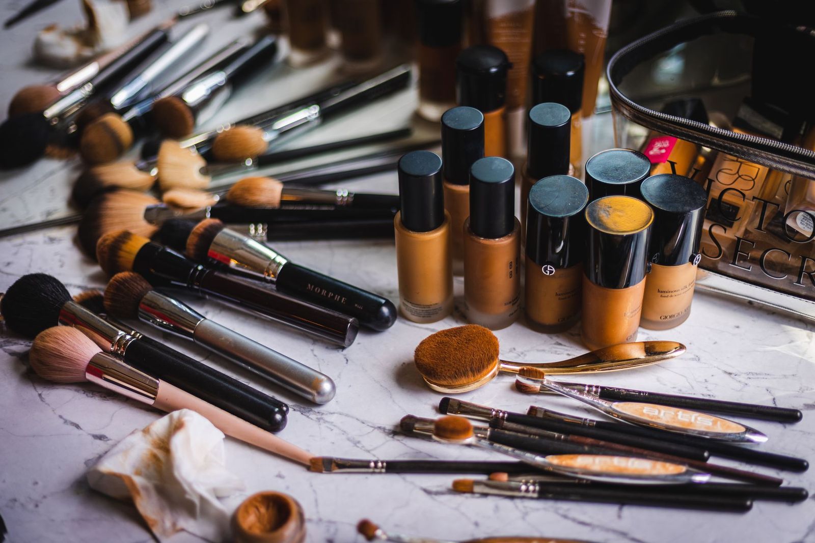 Make-up-Pinsel und Foundation-Flaschen auf Marmor