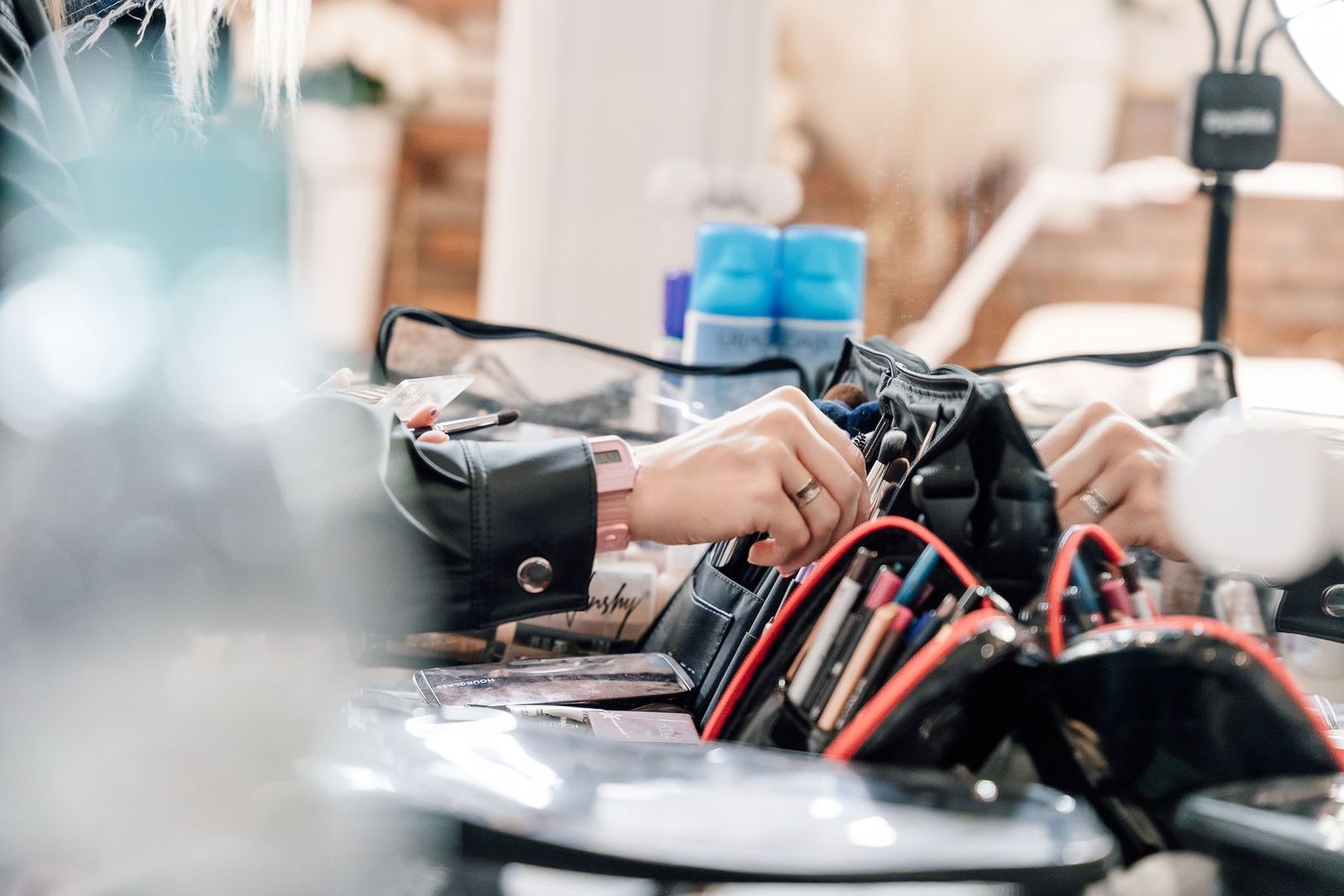 Make-up-Artistin ordnet Pinsel und Werkzeuge im Profi-Koffer